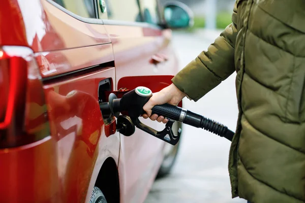 Primer plano de las manos de la mujer en la gasolinera de autoservicio, mantenga la boquilla de combustible y repostar el coche con gasolina, diesel, gas. Cierre de llenado automático con gasolina o bencina. Autoservicio bomba de gas — Foto de Stock