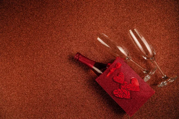Feliz San Valentín flatlay. Botella vista superior de champán rosa en caja de regalo, corazones, vasos sobre fondo de purpurina marrón. Tarjeta de felicitación de San Valentín o Año Nuevo —  Fotos de Stock