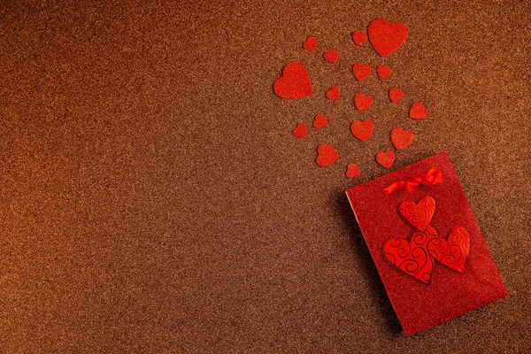 Felice San Valentino flatlay. Vista dall'alto regalo regalo scatola, cuori, bicchieri su sfondo glitter marrone. Biglietto di auguri per San Valentino o Capodanno — Foto Stock