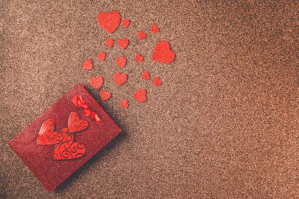 Všechno nejlepší k Valentýnovi. Horní pohled dárek box, srdce, brýle na hnědém třpytivém pozadí. Valentýn nebo novoroční přání — Stock fotografie