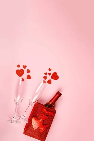 Glad Alla hjärtans dag flatlay. Ovanifrån flaska ros champagne i presentförpackning, hjärtan, glasögon på mjuk rosa bakgrund. Alla hjärtans dag eller nyår gratulationskort — Stockfoto