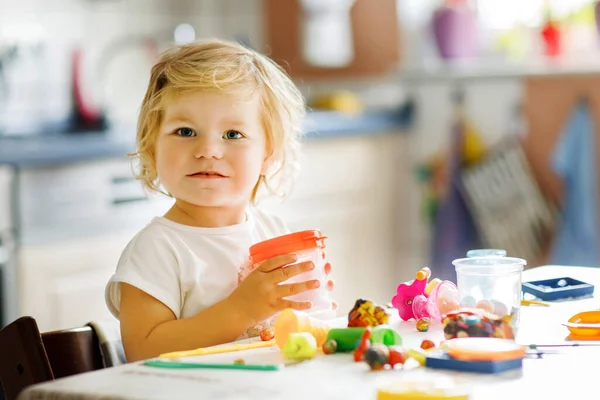 Urocza, słodka dziewczynka z kolorową gliną. Zdrowe dziecko bawiące się i tworzące zabawki z ciasta gry. Mały dzieciak formowanie modelowania gliny i uczenia się — Zdjęcie stockowe