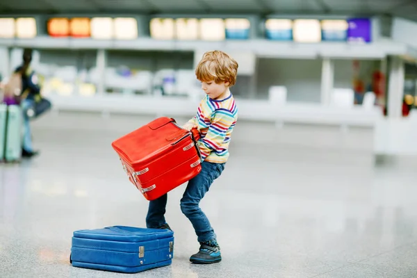 Happy little kid boy with big suitcase luggage at terminal on international airport. Preschool excited child wait for flight and going on vacations. Travel family lifestyle. — Stock Photo, Image