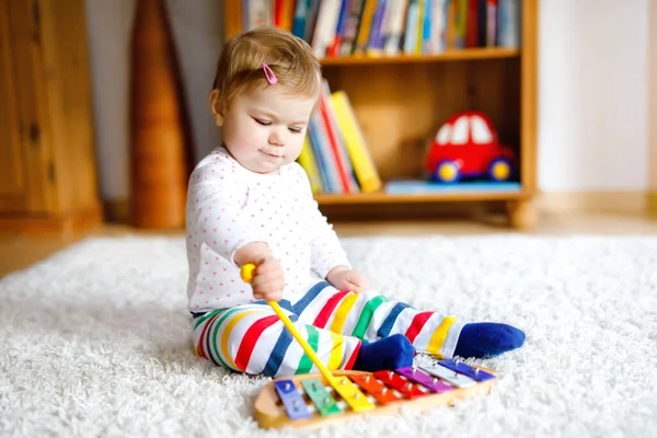 사랑스럽고 귀여운 작은 여아가 집이나 보육원에서 교육용 장난감을 가지고 놀고 있다. 건강하고 건강 한 아이가 다채 로운 음악 장난감 xylophone Kid 가 서로 다른 기술을 배우는 것을 즐기는 모습 — 스톡 사진