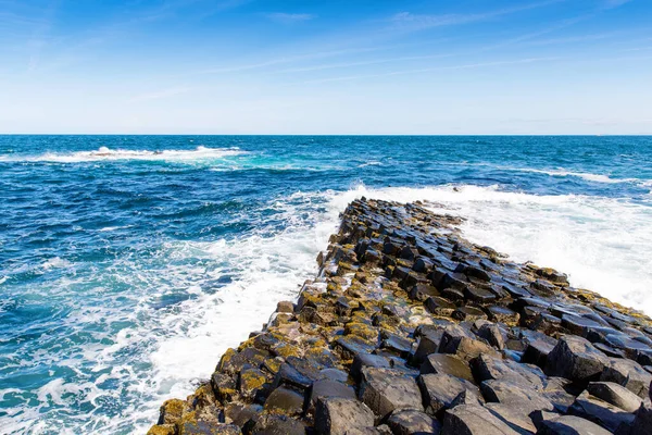 Paisagem dos Gigantes Causeway trilha com um céu azul no verão, na Irlanda do Norte, County Antrim. Património da UNESCO. É uma área de colunas de basalto, o resultado de uma antiga erupção de fissura vulcânica — Fotografia de Stock