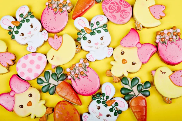 Primo piano di variazione di biscotti da zucchero pasquali diversi decorati con glassa reale. Uova, coniglietto, carote e pollo su fondo giallo. Delizioso regalo dolce o cartolina — Foto Stock