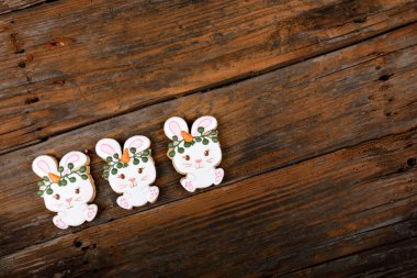 Kraliyet şekeriyle süslenmiş farklı Paskalya şekerli kurabiyelerin yakın çekimleri. Ahşap arka planda havuçlu tavşan. Tatlı bir hediye veya kartpostal.