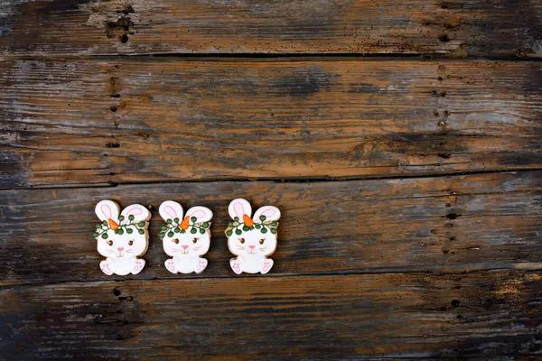 Kraliyet şekeriyle süslenmiş farklı Paskalya şekerli kurabiyelerin yakın çekimleri. Ahşap arka planda havuçlu tavşan. Tatlı bir hediye veya kartpostal. — Stok fotoğraf
