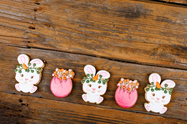 Primo piano di variazione di biscotti da zucchero pasquali diversi decorati con glassa reale. Coniglio coniglietto con carote e uova su sfondo di legno. Delizioso regalo dolce o cartolina — Foto Stock