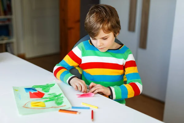Little kid boy making paper origami tulip flowers for a postcard for mothers day or birthday. Child on home schooling in coronavirus covid time, schools closed. Homeschooling concept — Stock Photo, Image