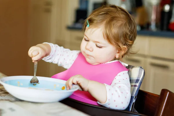 Adorable baby girl eating from spoon mashed vegetables and puree. food, child, feeding and people concept