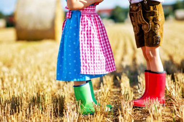 Geleneksel Bavyera kostümlü iki çocuk ve kırmızı ve yeşil ovalama