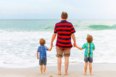 İki mutlu küçük çocuk okyanus sahilinde durup fırtınalı bir günde ufka bakıyorlar. Aile, baba ve tatlı oğullar tatil yapıyor, hayal kuruyor ve yazın tadını çıkarıyorlar.