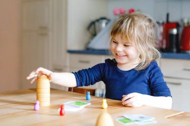 Salon oyunu oynayan sevimli küçük kız. Mutlu sağlıklı çocuk hafızasını eğitiyor, düşünüyor. Salgın Coronavirus covid karantina hastalığı sırasında çocuğun evde dinlenmesi ve eğitilmesi