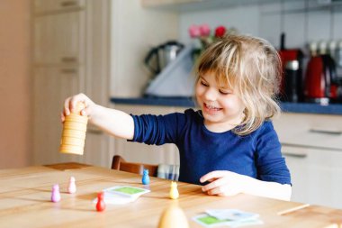 Salon oyunu oynayan sevimli küçük kız. Mutlu sağlıklı çocuk hafızasını eğitiyor, düşünüyor. Salgın Coronavirus covid karantina hastalığı sırasında çocuğun evde dinlenmesi ve eğitilmesi