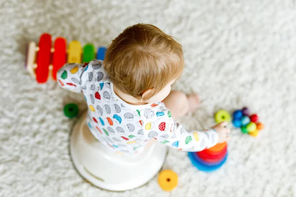 Closeup of cute little 12 months old toddler baby girl child sitting on potty.