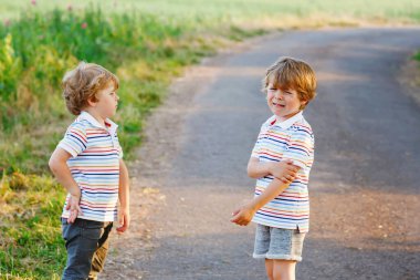 İki küçük kardeş kavga ediyor. İkizler, dışarıda kavga eden üzgün çocuklar. Rekabet ve kardeşler arasındaki rekabet. Mutsuz ikizler. Bir çocuk ağlıyor..