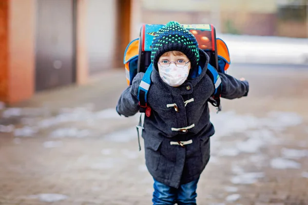 Маленький смішний хлопчик в окулярах з медичною маскою на шляху до школи. Дитина з сателітом розважається. Шкільний малюк. Блокування та карантинний час під час пандемії коронавірусу — стокове фото