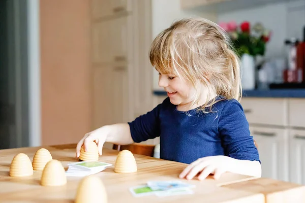 Adorable cute toddler girl playing parlor game. Happy healthy child training memory, thinking. Creative indoors leisure and education of kid during pandemic coronavirus covid quarantine disease — Stock Photo, Image