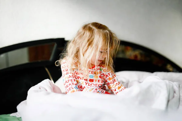 Menina da criança se divertindo na cama depois de acordar. Crianças saudáveis pulam e brincam às escondidas com os pais. Criança adorável em casa, estilo de vida familiar. — Fotografia de Stock