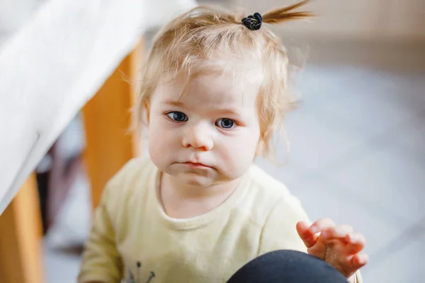 Petite fille apprend à marcher, à se tenir debout et à faire les premiers pas à la maison. Équilibrage des tout-petits. Enfant heureux, équilibre et développement — Photo