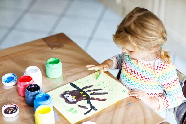 Küçük, yaratıcı, küçük bir kız parmak boyası ile bir baykuş resmi yapıyor. Aktif çocuk evde çizim yaparken eğleniyor, anaokulunda ya da anaokulunda. Çocuklar için oyunlar, eğitim ve mesafe öğrenimi — Stok fotoğraf