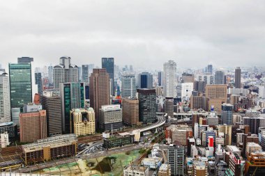 OSAKA, JAPONYA - 18 Mayıs 2015: Japonya 'daki Osaka şatosunun tepesinden gökdelenler, otobanlar ve parklarla Osaka şehrinin ufuk çizgisine bakın. Osaka ilinin başkentidir..