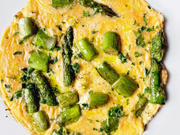 Top view on egg omelette with fresh green asparagus and parsley. Healthy vegan and vegetarian omelet for breakfast or lunch food. Close-up of plate — Stock Photo, Image
