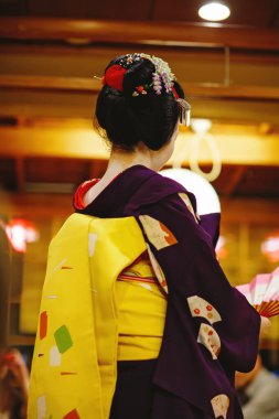 Maiko çırağı Japon geleneksel dansını gösteriyor. Maiko bir çırak geyşa. Maikos ozashiki 'deki ziyaretçiler için şarkı söylüyor, shamisen çalıyor veya enstrümanlar çalıyor.