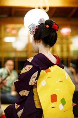 Maiko çırağı Japon geleneksel dansını gösteriyor. Maiko bir çırak geyşa. Maikos ozashiki 'deki ziyaretçiler için şarkı söylüyor, shamisen çalıyor veya enstrümanlar çalıyor.