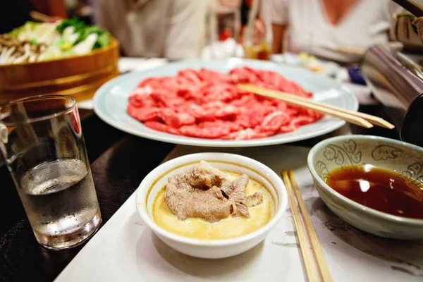 Shabu-shabu to japoński nabemono hotpot danie cienko krojone mięso i warzywa gotowane w wodzie i podawane z sosami zanurzeniowymi. Przygotowanie shabu shabu — Zdjęcie stockowe