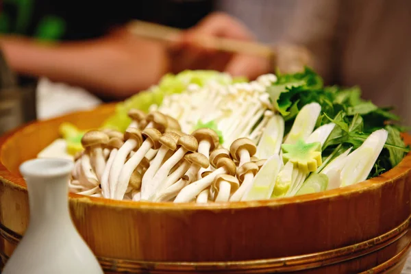 Shabu-shabu egy japán nabemono forró pot étel vékonyra szeletelt hús és zöldség főtt vízben és mártással tálalva. A shabu shabu elkészítése — Stock Fotó