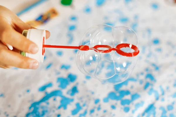 Closeup of hands of playing child with soap bubbles at home. Kid having fun. Child playing at school, making experiment with soap and water. Copy space for text — Stock Photo, Image