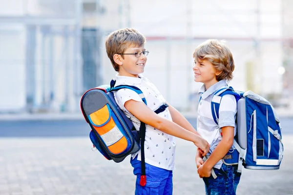 To små guttunger med sekker. Skoleunger på vei til skolen. Lykkelige barn, brødre og bestevenner tilbake til skolen etter at Corona virus covid 19 karantene. – stockfoto