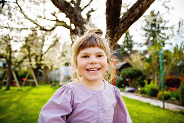 Retrato da menina sorridente feliz da criança ao ar livre. Criança pequena com cabelos loiros olhando e sorrindo para a câmera. Criança saudável feliz desfrutar de atividade ao ar livre e brincar. — Fotografia de Stock