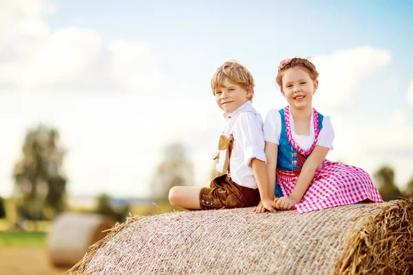 Twee kinderen, jongen en meisje in traditionele Beierse kostuums in tarweveld — Stockfoto