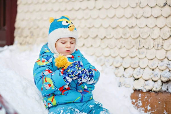 可爱的学龄前小男孩穿着五颜六色的冬衣，在雪地里玩着雪和雪花。冬天和孩子们一起积极地在户外休闲.快乐的孩子在家里的楼梯上滑行 — 图库照片