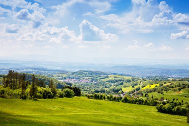 Landscape on Hoherodskopf, volcano region in Hesse, Germany. On cloudy sunny warm summer day, meadows, hills, fields and forests. clipart
