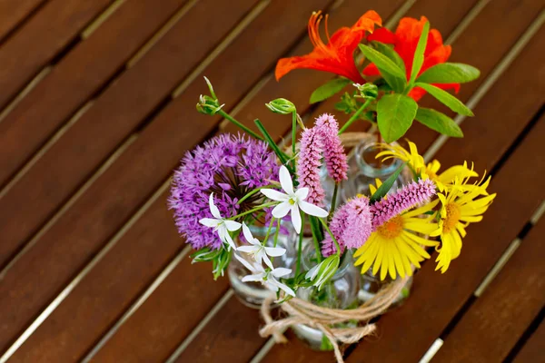 Variation or group of garden flowers in small vases or bottles. Colorful flower arrangement or decoration in rainbow colors. Home or garden, terrace decor concept. — Stock Photo, Image