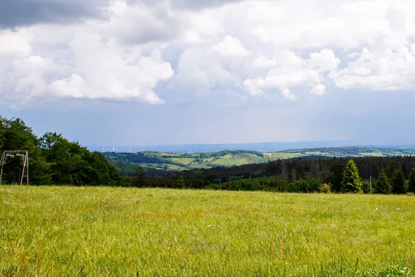 Paisagem sobre Hoherodskopf, região vulcânica de Hesse, Alemanha. No dia quente ensolarado nublado do verão, prados, colinas, campos e florestas. — Fotografia de Stock