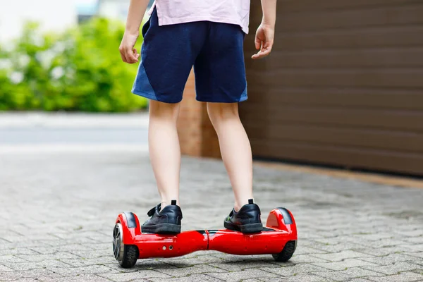 Nahaufnahme eines Jungen auf einem Schwebebrett. Kind fährt modernes Balance-Hoverboard. Bewegung und Sport für Kinder, Outdoor-Aktivitäten für kleine Kinder. — Stockfoto