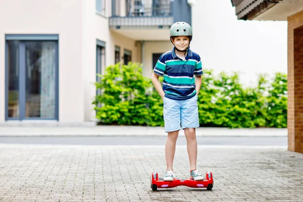 Un chico activo en la tabla flotante. Niño conduciendo hoverboard equilibrio moderno. Ejercicio y deportes para niños, actividad al aire libre para niños pequeños. — Foto de Stock