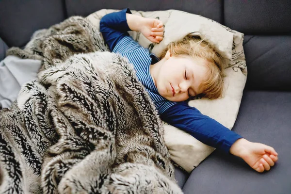 Симпатичная маленькая девочка спит в постели. Очаровательный ребенок мечтает, здоровый сон детей днем. — стоковое фото
