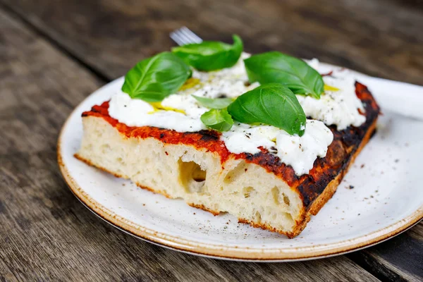 Verse focaccia met tomaat, basilicum en geitenkwark op houten tafel. Italiaanse levensmiddelen. — Stockfoto
