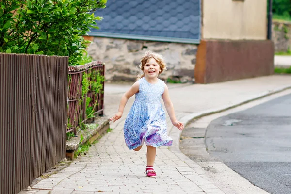Menina pequena feliz correndo na rua na cidade, ao ar livre. Hilo infantil pré-escolar engraçado se divertindo com corrida, caminhando, pulando no dia ensolarado de verão. Lazer familiar ativo no verão. — Fotografia de Stock