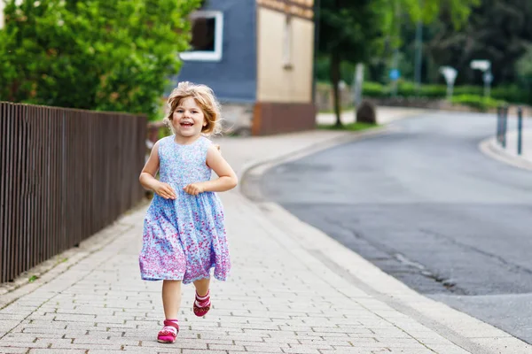 Feliz niñita corriendo por la calle en la ciudad, al aire libre. Divertido niño preescolar hild divertirse con correr, caminar, saltar en el día de verano soleado. Ocio familiar activo en verano. —  Fotos de Stock