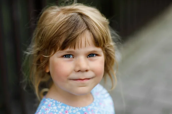 幸せな笑顔の幼児の女の子の屋外の肖像画。金髪の小さな子供がカメラを見て笑っています。幸せな健康な子供は屋外活動を楽しみ、遊ぶ. — ストック写真