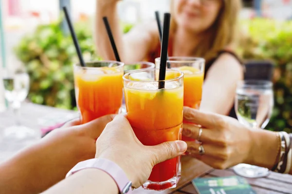 Persone bicchieri di clinking con cocktail, aperol e vino sulla terrazza estiva di caffè o ristorante. Donne amiche divertirsi insieme il giorno d'estate. — Foto Stock