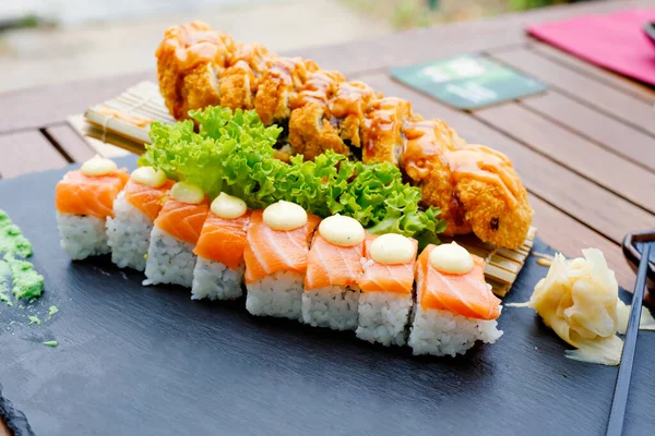 Sushi-Set rollen kalifornische Garnelen. Traditionelle japanische Fusionsküche Lieferung von Lebensmitteln auf Qurantin. Reis, Nori, Tigergarnelen, Gurken, Avocado, Gewürzsoße, Masago-Kaviar. — Stockfoto