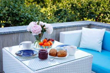 Romantik çiftler için yaz sabahı balkonlu terasta ya da otelde sunulan ekmek, taze meyve, çilek ve kahveyle kahvaltı masası..